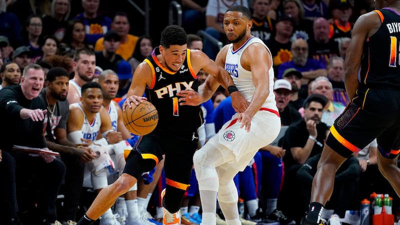 Phoenix Suns guard Devin Booker (1) drives around Los Angeles Clippers guard Eric Gordon (10)...