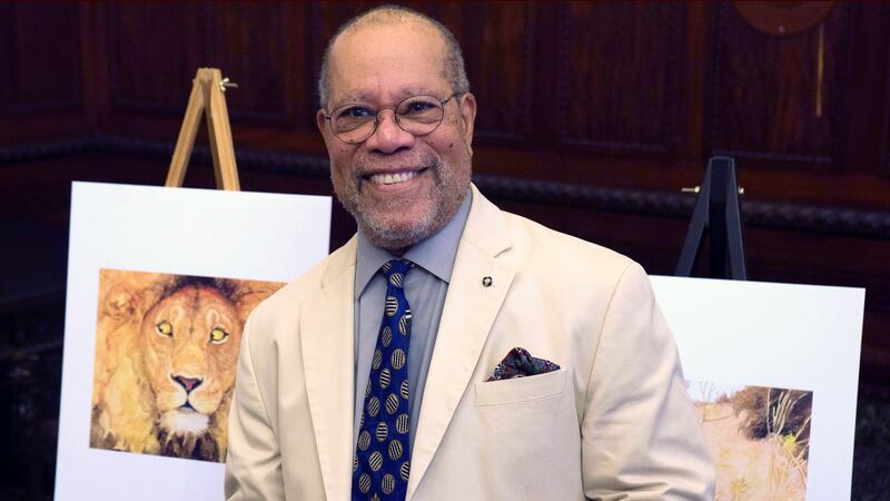 Children's book illustrator Jerry Pinkney poses in front of two of his illustrations Tuesday,...